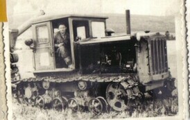 Młody mężczyzna w szoferce traktora gąsienicowego