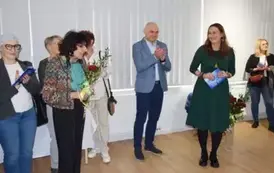 Wręczenie kwiat&oacute;w byłej kierownik Muzeum przez obecną w towarzystwie Dyrektora Miejskiego Centrum Kultury