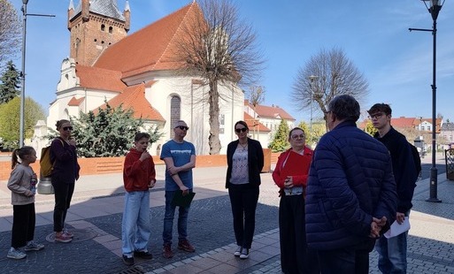 Zdjęcie przedstawia uczestników spaceru poszukujacych kamiennych odbojów.